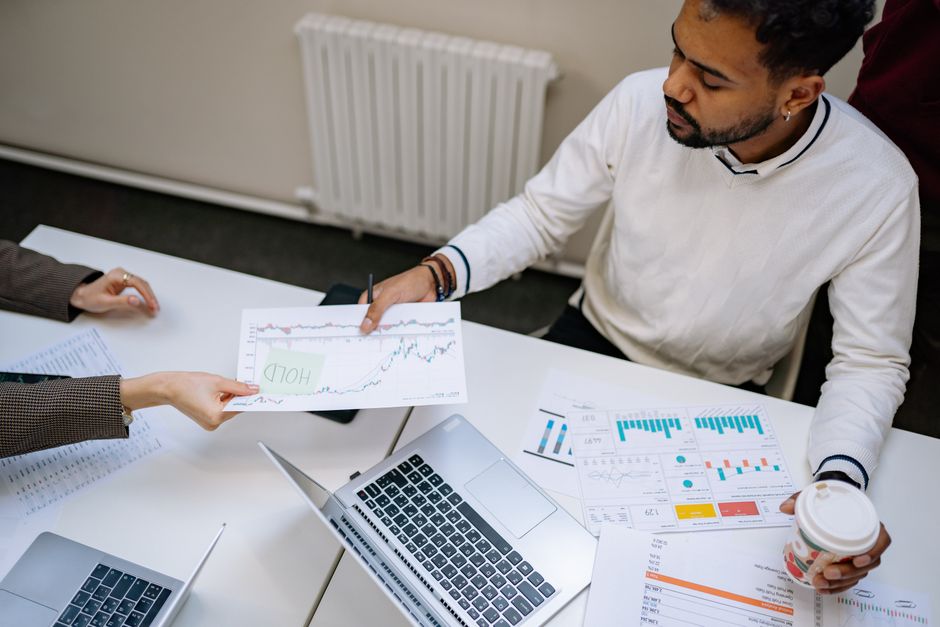 Colleagues collaborating on financial charts and data during a business meeting indoors.